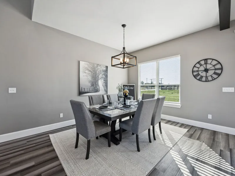 Dining room with dark table for six, window light, and wide-plank floors