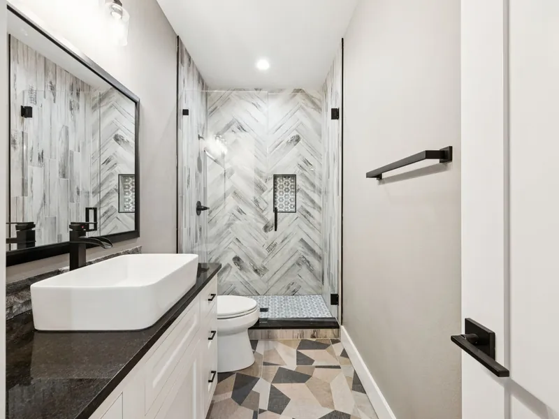Shelter bathroom with tiled walk-in shower and vessel-sink vanity