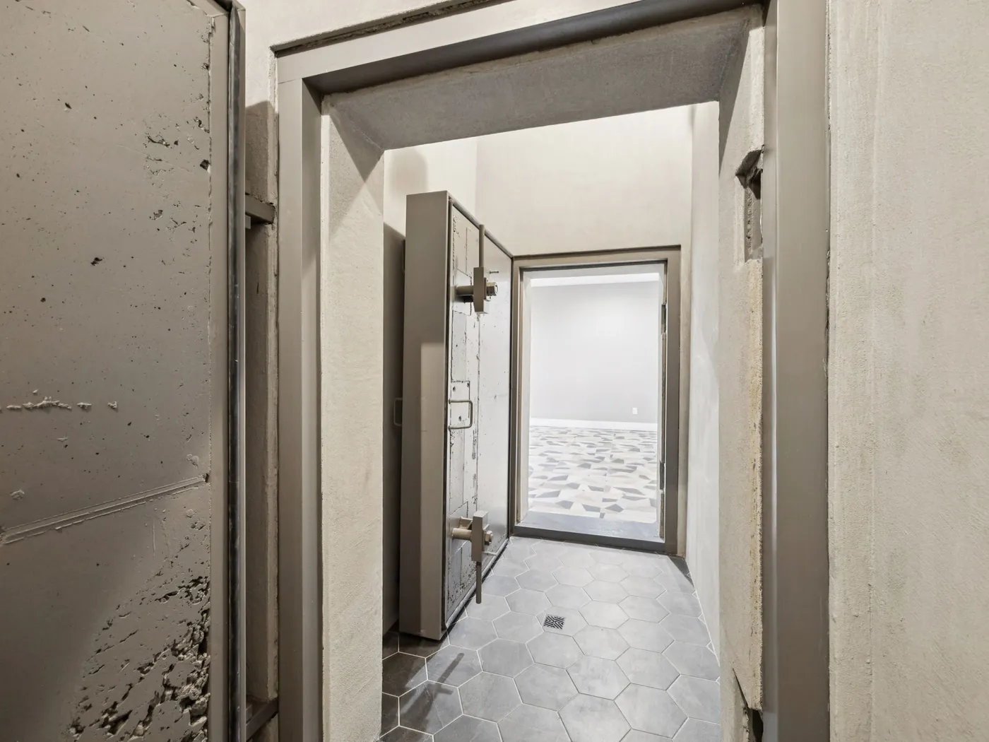Steel blast door standing open in the poured-concrete entry corridor of an Ark Industries shelter