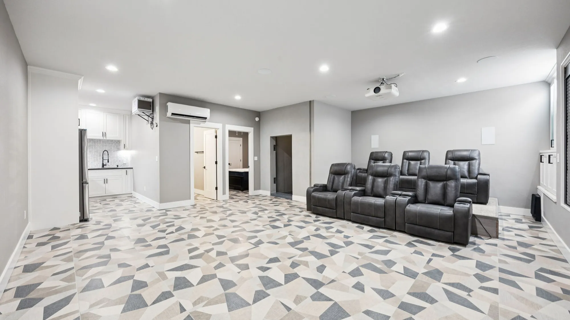 Underground shelter theater room with rows of leather recliners facing a projection screen